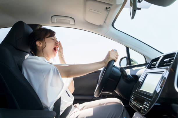 yawning female driver falling asleep at the wheel concept